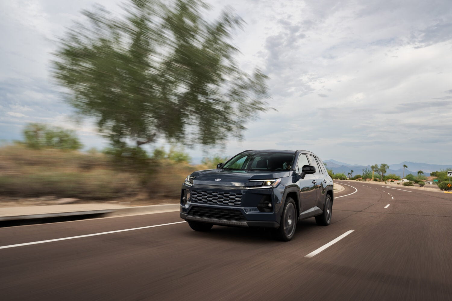 2026 Toyota RAV4 HEV racing down an open road